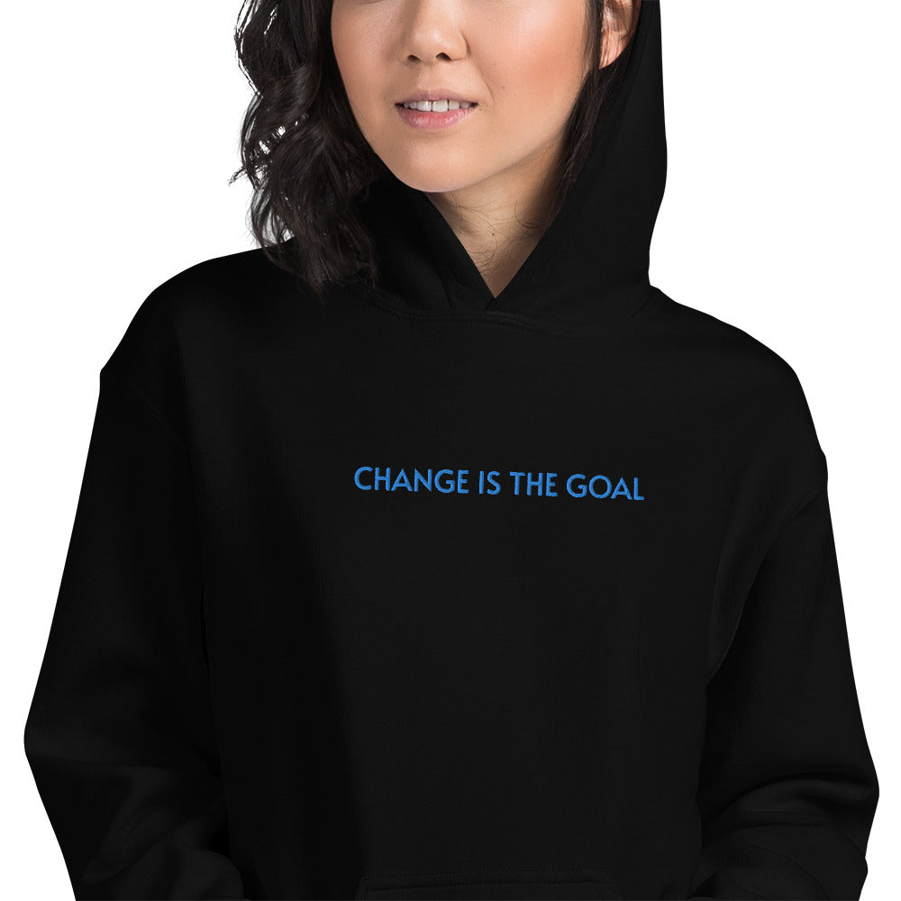 a woman wearing black  wrath   hoodie with change is the goal embroidery at the center chest